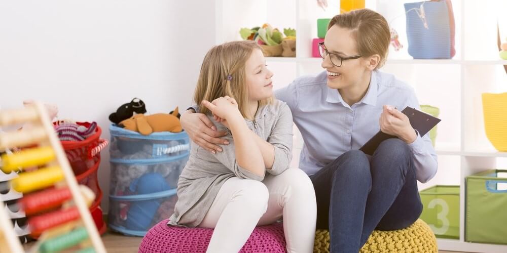 Woman child therapist working with little girl