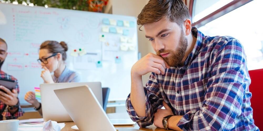 Male student using a laptop for an online psychology class