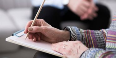 Image of older woman's hands signing up for psychology class