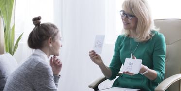 Young woman in therapy session with female educational therapist