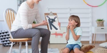 Little boy smiling at drawing of a rabbit during child psychology session