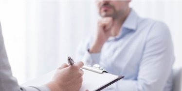 Psychologist taking notes with patient during a session.