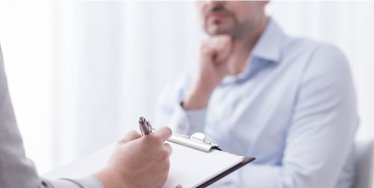 Psychologist taking notes with patient during a session.