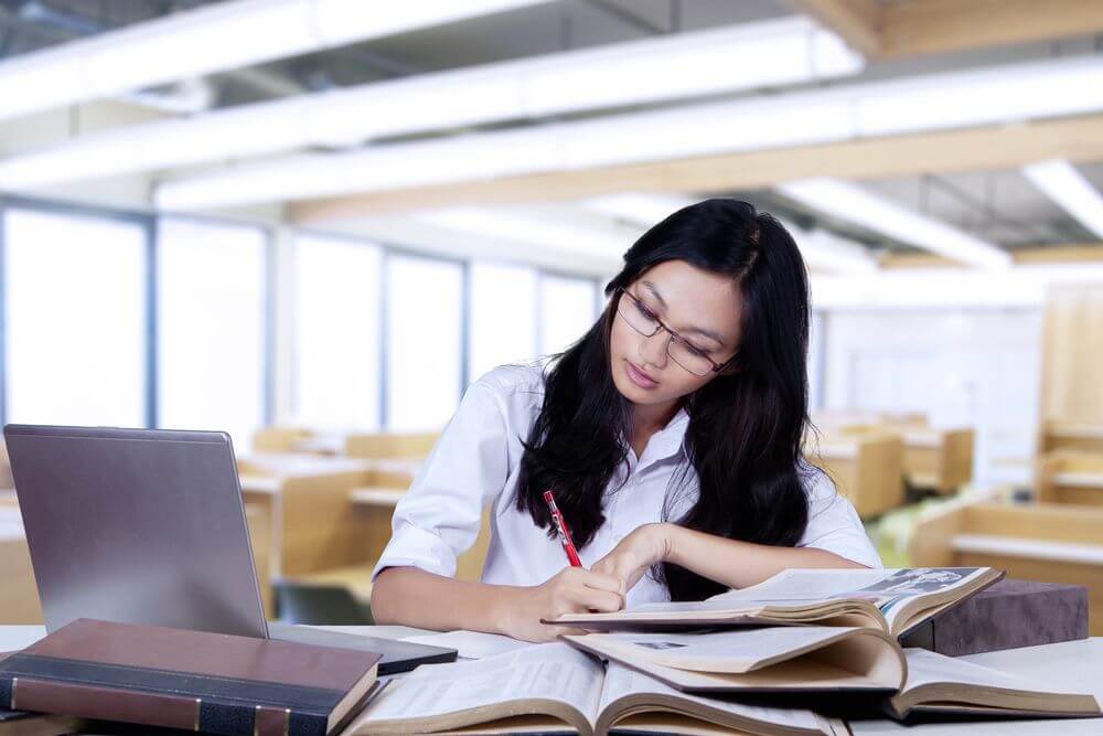 Montana Student Studying Online In Library for Online Psychology Doctorate Degree