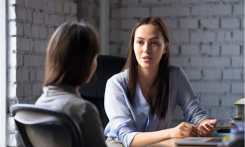 Two women having a serious conversation at a table